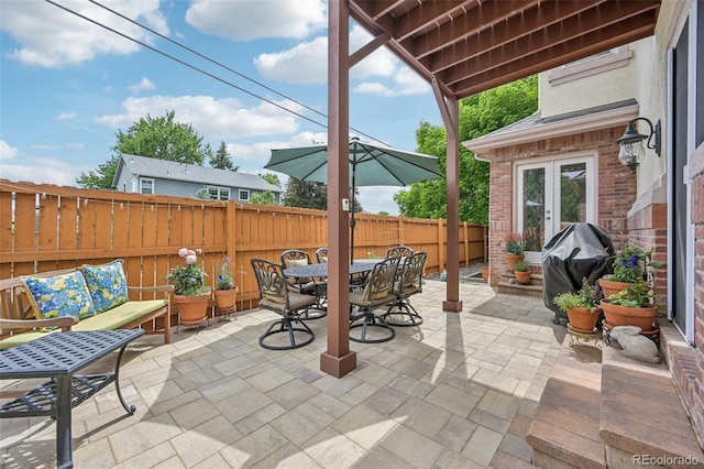 view of patio / terrace with outdoor dining area, fence private yard, outdoor lounge area, area for grilling, and french doors