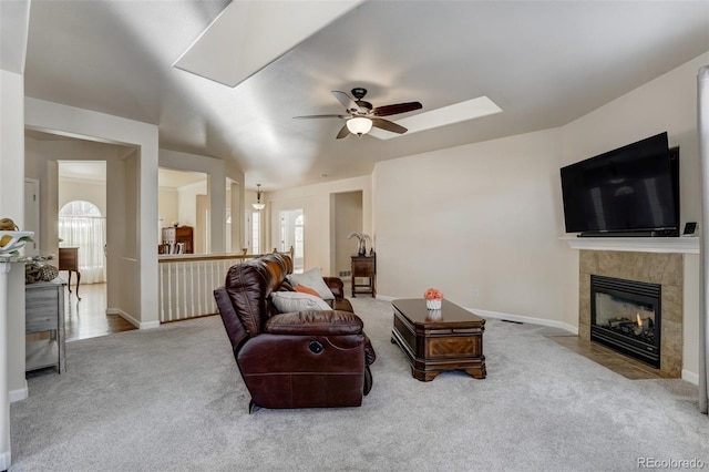 carpeted living room with ceiling fan and a fireplace