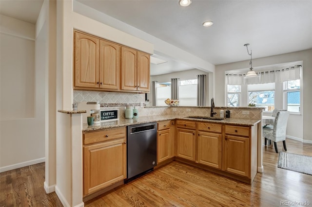 kitchen with pendant lighting, dishwasher, sink, backsplash, and light hardwood / wood-style floors