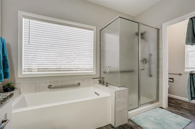 bathroom featuring wood-type flooring, a wealth of natural light, and separate shower and tub