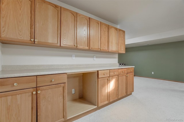 kitchen featuring built in desk and light brown cabinets