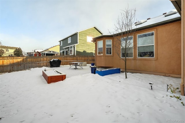 view of snow covered back of property