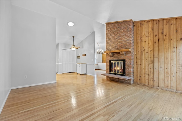 7888 S Poplar Way, Centennial, CO 80112 - unfurnished living room with high vaulted ceiling, wood finished floors, a ceiling fan, a fireplace, and wooden walls