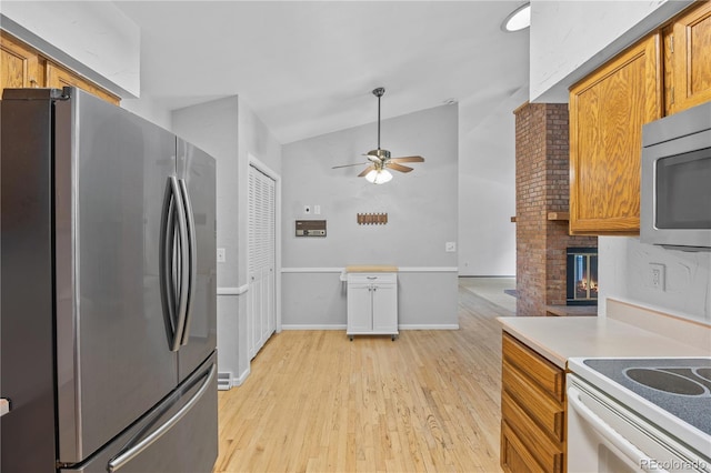 7888 S Poplar Way, Centennial, CO 80112 - kitchen featuring stainless steel appliances, a ceiling fan, light wood finished floors, brown cabinetry, and vaulted ceiling