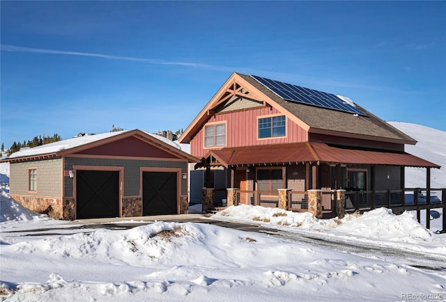 view of front of house featuring covered porch, solar panels, and an outdoor structure