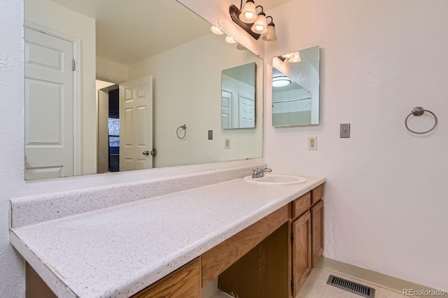 bathroom featuring visible vents, vanity, and tile patterned flooring