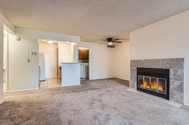 unfurnished living room with a textured ceiling, light carpet, a tile fireplace, and ceiling fan