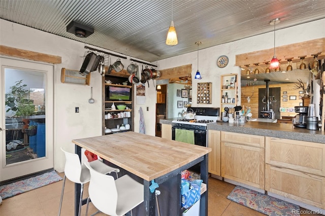 kitchen with pendant lighting, light brown cabinets, wood counters, and light tile patterned flooring