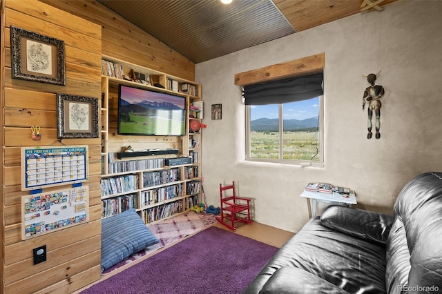 living area featuring lofted ceiling, wood ceiling, and wooden walls