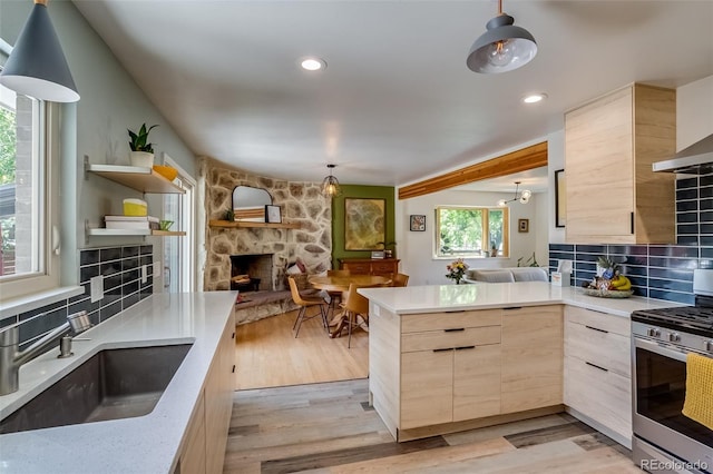 3010 Zinnia Ct, Golden, CO 80401 - kitchen featuring stainless steel gas range, light brown cabinets, a fireplace, a sink, and open floor plan