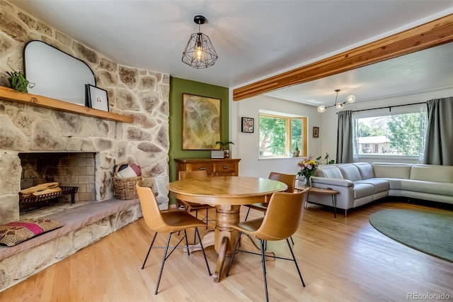 3010 Zinnia Ct, Golden, CO 80401 - dining room featuring wood finished floors, a fireplace, and beamed ceiling