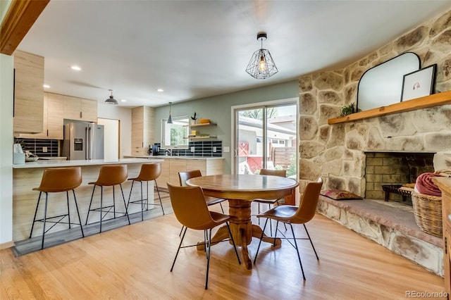 3010 Zinnia Ct, Golden, CO 80401 - dining area featuring light wood-style flooring, a stone fireplace, and recessed lighting