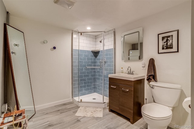 3010 Zinnia Ct, Golden, CO 80401 - bathroom featuring a stall shower, vanity, wood finished floors, toilet, and baseboards