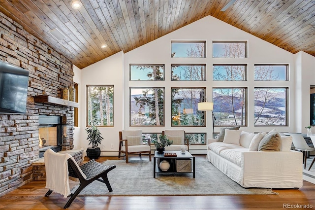 living room featuring high vaulted ceiling, wooden ceiling, wood-type flooring, and a fireplace