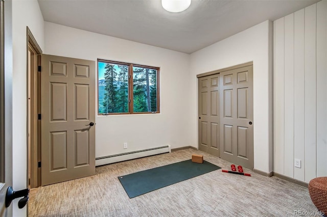 exercise room with a baseboard heating unit