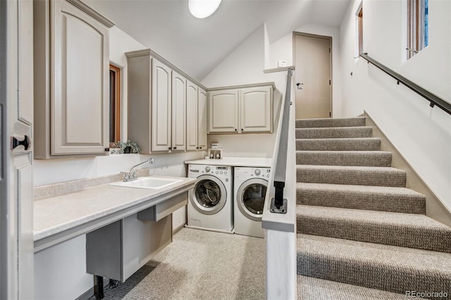 laundry room featuring washing machine and dryer, cabinets, and sink