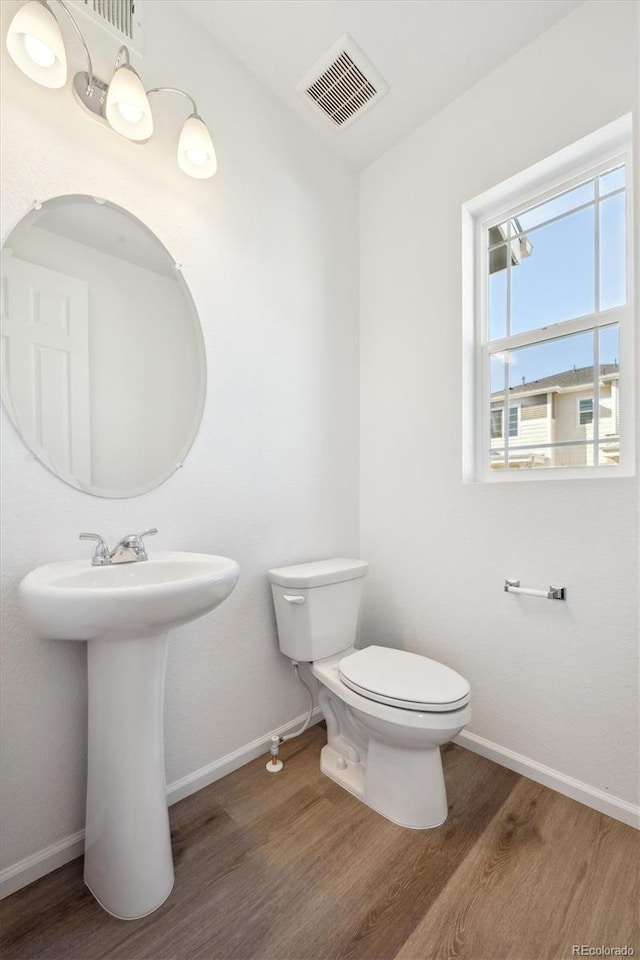 bathroom featuring hardwood / wood-style flooring, toilet, and sink