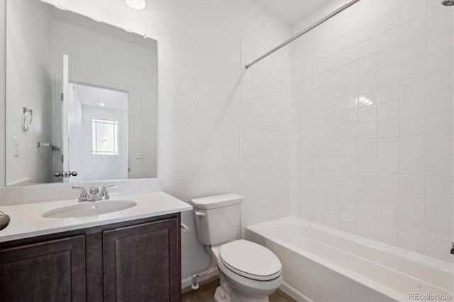 full bathroom with vanity, tiled shower / bath, and toilet