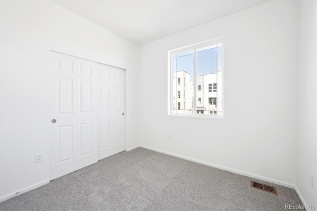 unfurnished bedroom with carpet flooring and a closet