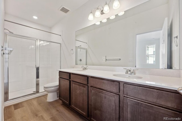 bathroom featuring vanity, wood-type flooring, toilet, and walk in shower