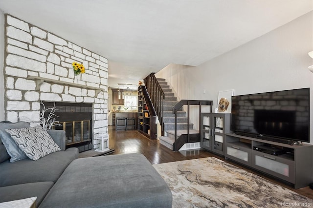 living room featuring stairs, a fireplace, and wood finished floors