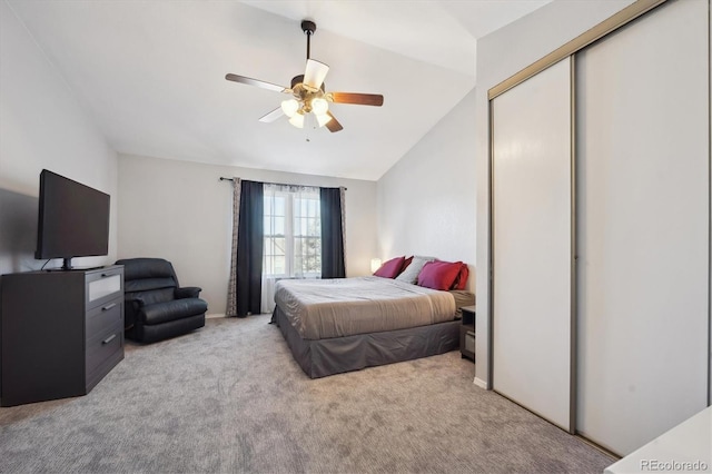 carpeted bedroom with a ceiling fan, a closet, and vaulted ceiling