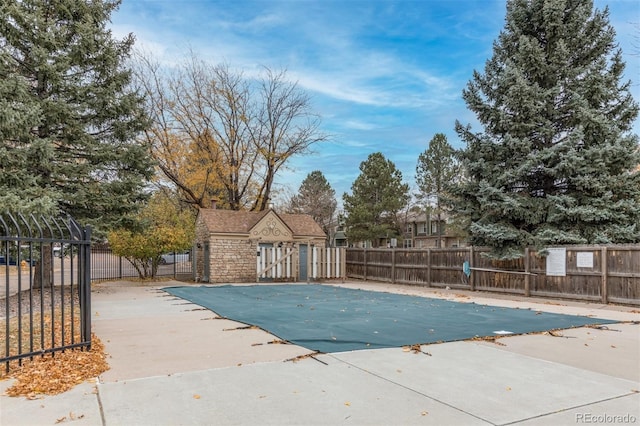 pool with a patio area and fence