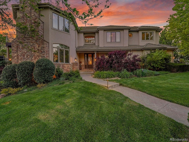 291 Fairchild Dr, Highlands Ranch, CO 80126 - view of front of house featuring stucco siding, a yard, stone siding, and a chimney