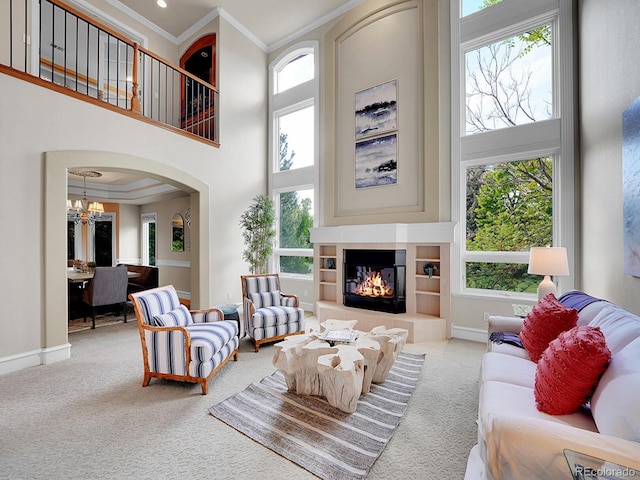 291 Fairchild Dr, Highlands Ranch, CO 80126 - living room with a towering ceiling, ornamental molding, carpet, arched walkways, and a chandelier