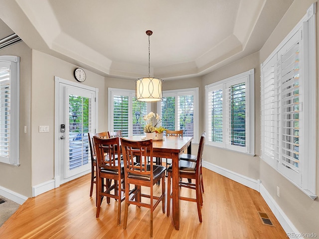291 Fairchild Dr, Highlands Ranch, CO 80126 - dining area featuring a raised ceiling, light wood-type flooring, and baseboards