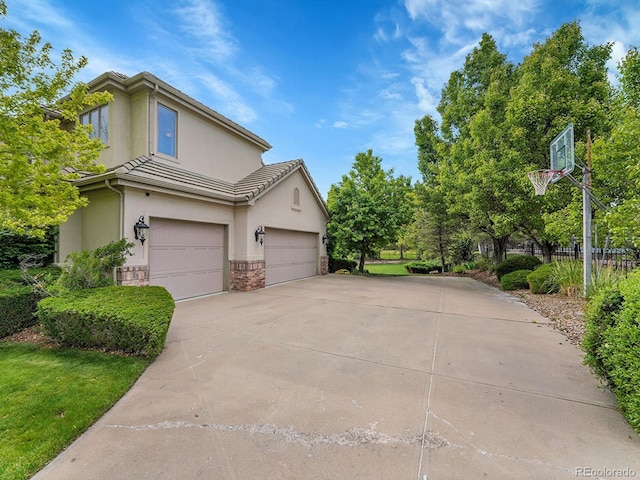 291 Fairchild Dr, Highlands Ranch, CO 80126 - view of side of property featuring stucco siding, concrete driveway, an attached garage, and a tile roof