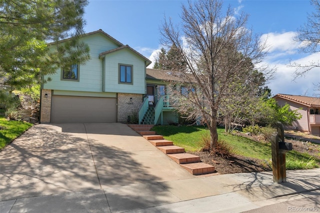 1045 Golden Hills Rd, Colorado Springs, CO 80919 - tri-level home with stairway, brick siding, an attached garage, and driveway