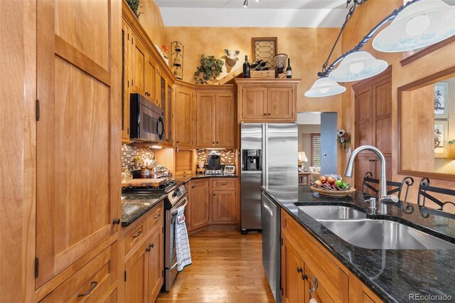 1045 Golden Hills Rd, Colorado Springs, CO 80919 - kitchen with brown cabinetry, tasteful backsplash, light wood-type flooring, a sink, and stainless steel appliances