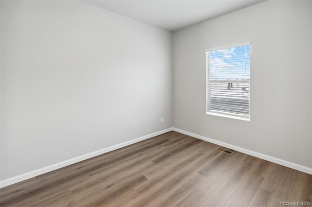 unfurnished room featuring wood finished floors and baseboards