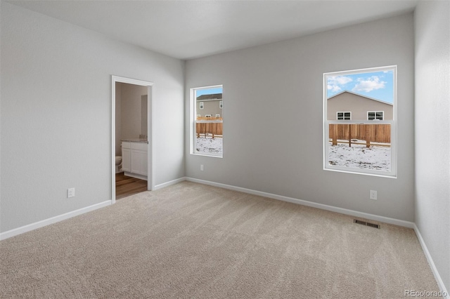 carpeted empty room featuring baseboards