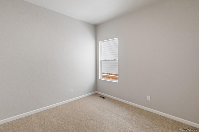 spare room with carpet and baseboards