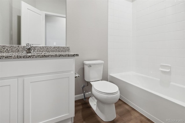 bathroom with wood finished floors, toilet, vanity, shower / tub combination, and baseboards
