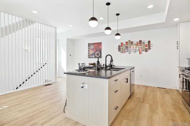 kitchen with pendant lighting, an island with sink, stainless steel appliances, and sink