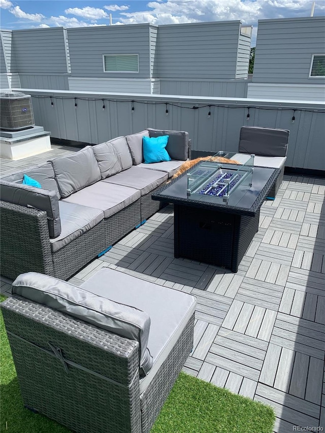 view of patio with an outdoor living space with a fire pit and central AC unit