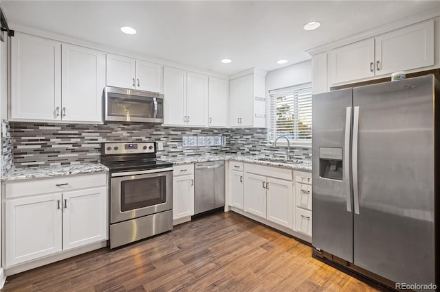 kitchen featuring sink, stainless steel appliances, light stone counters, white cabinets, and dark hardwood / wood-style flooring