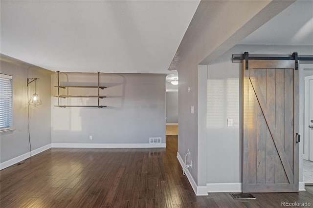 interior space featuring a barn door and dark wood-type flooring