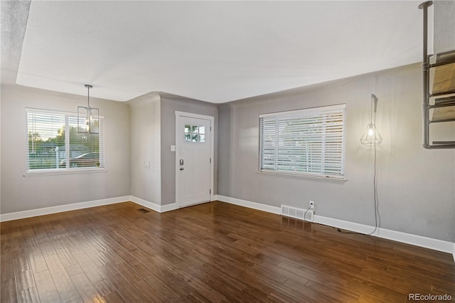 foyer with a chandelier and dark hardwood / wood-style flooring