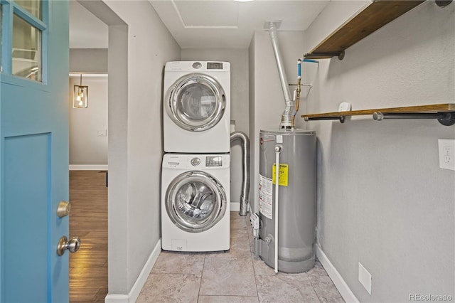 clothes washing area with water heater and stacked washer / dryer