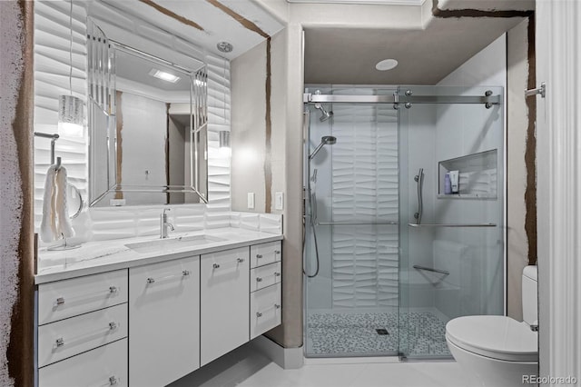 bathroom featuring vanity, an enclosed shower, and toilet