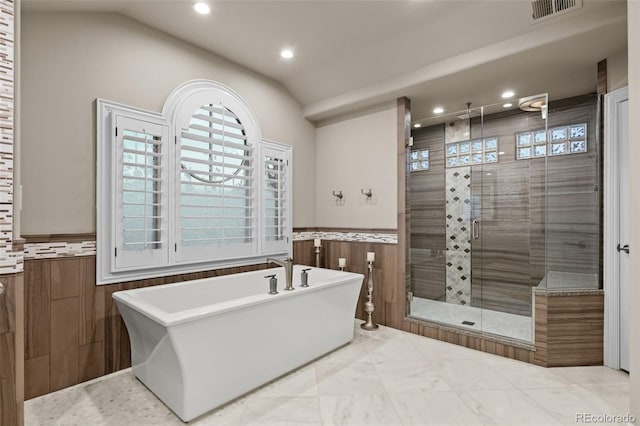 bathroom with plus walk in shower, vaulted ceiling, and tile walls