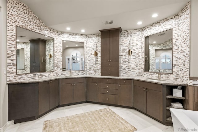 bathroom featuring vanity, a tub to relax in, and lofted ceiling