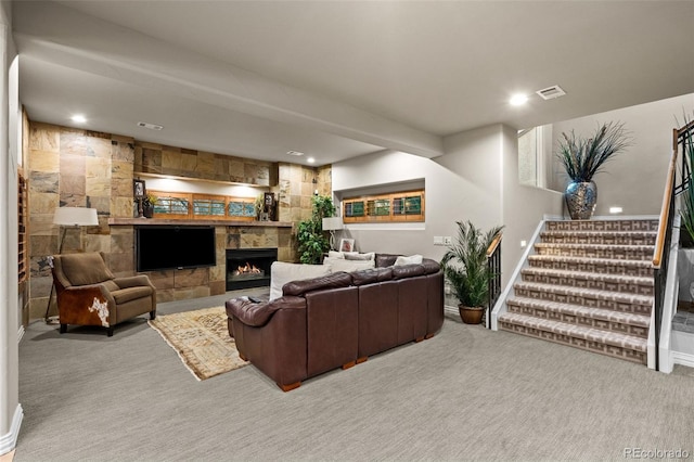 carpeted living room featuring a tile fireplace