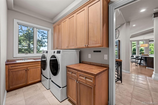 laundry area with sink, cabinets, and independent washer and dryer