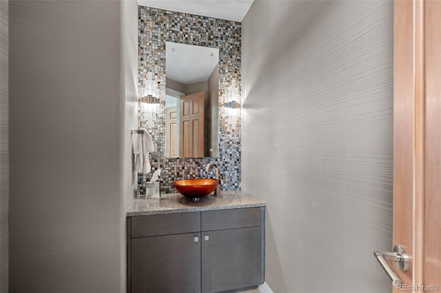 bathroom featuring tasteful backsplash, vanity, and tile walls