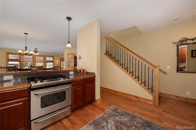 230 Buckhorn Cir, Granby, CO 80446 - kitchen with gas range, light wood-style flooring, a chandelier, pendant lighting, and tile counters